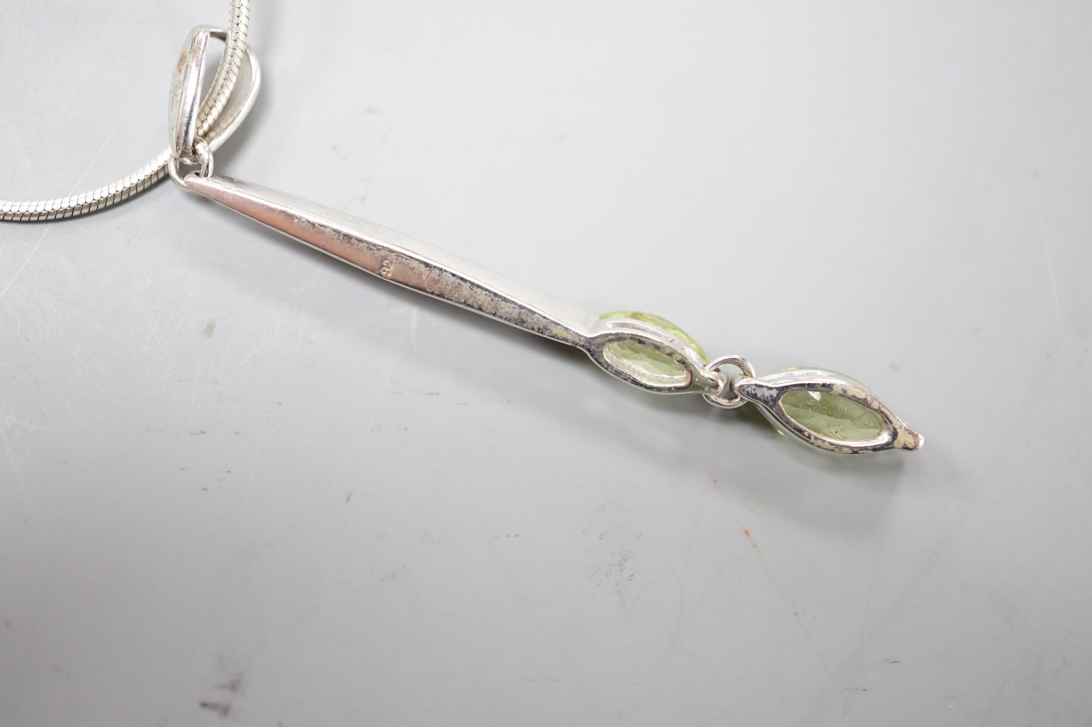 A modern 925 and two stone peridot set pendant,53mm, on a 925 chain, 42cm.